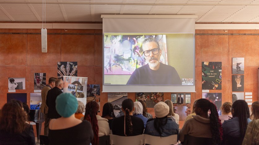 Författaren Jens Lapidus föreläser på en skärm.