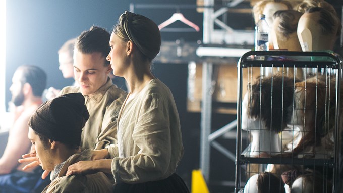 Människor bakom kulisserna på en teaterscen. 