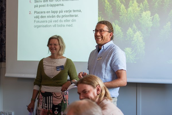 Mötet leds av Carlos Pettersson och Emma Willaredt, de ler mot deltagarna. 