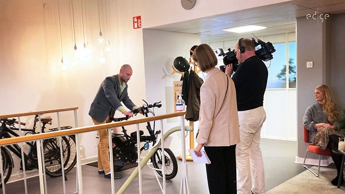 En man står och demonstrerar hur en elcykel fungerar.