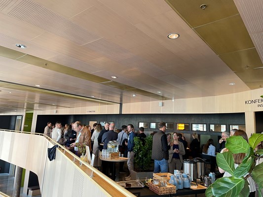Konferensdeltagare som står och minglar på Spiras balkong.