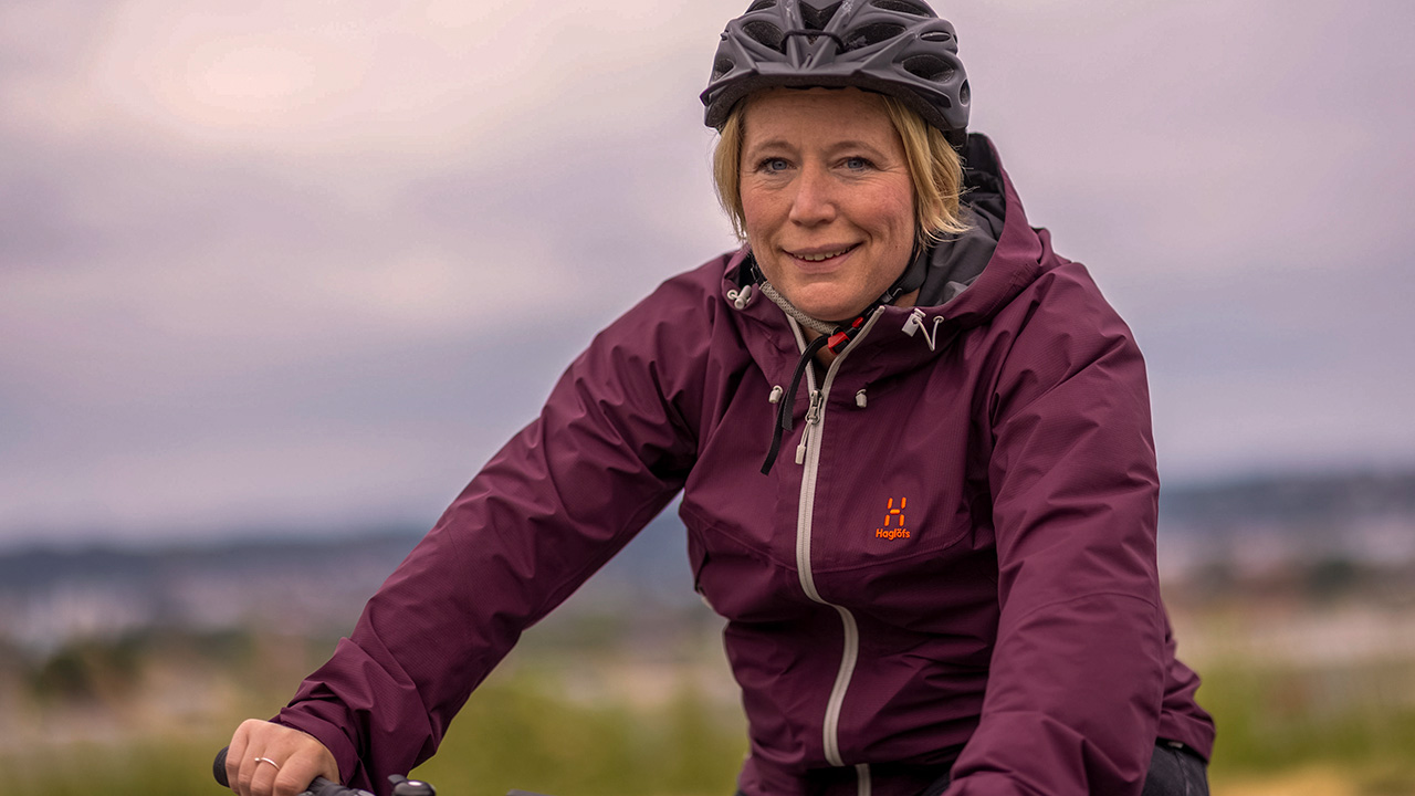 Leende kvinna som cyklar