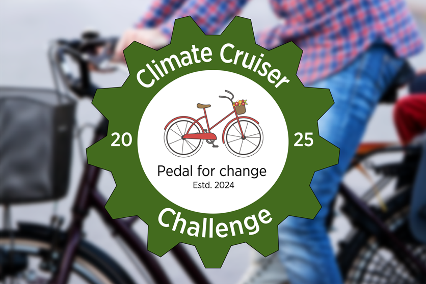 En inzoomad, suddig bild på en cykel med loggan för Climate Cruiser Challenge 2025. i loggan finns en röd cykel och texten "Pedal for change".