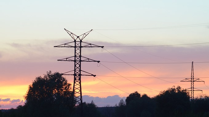 Kraftledningsstolpar i solnedgång.