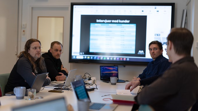 Möte mellan fyra personer runt ett konferensbord.