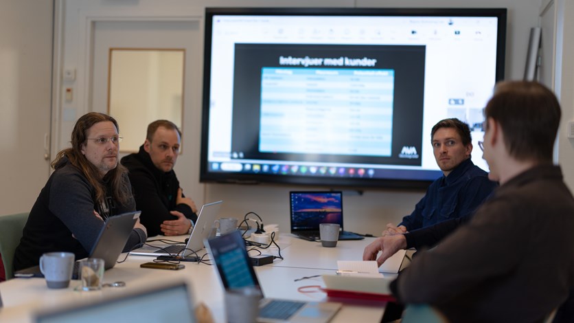 Möte mellan fyra personer runt ett konferensbord.