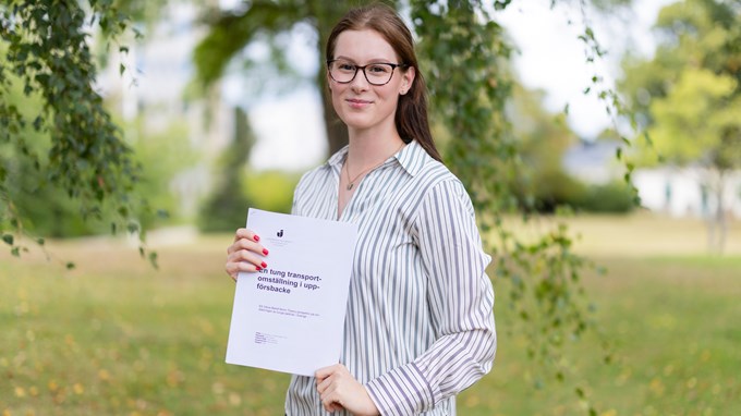 Joanne Öggesjö, i handen håller hon sitt examensarbete. 