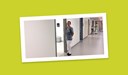 En medarbetare står i klinikens korridor och ler in i kameran