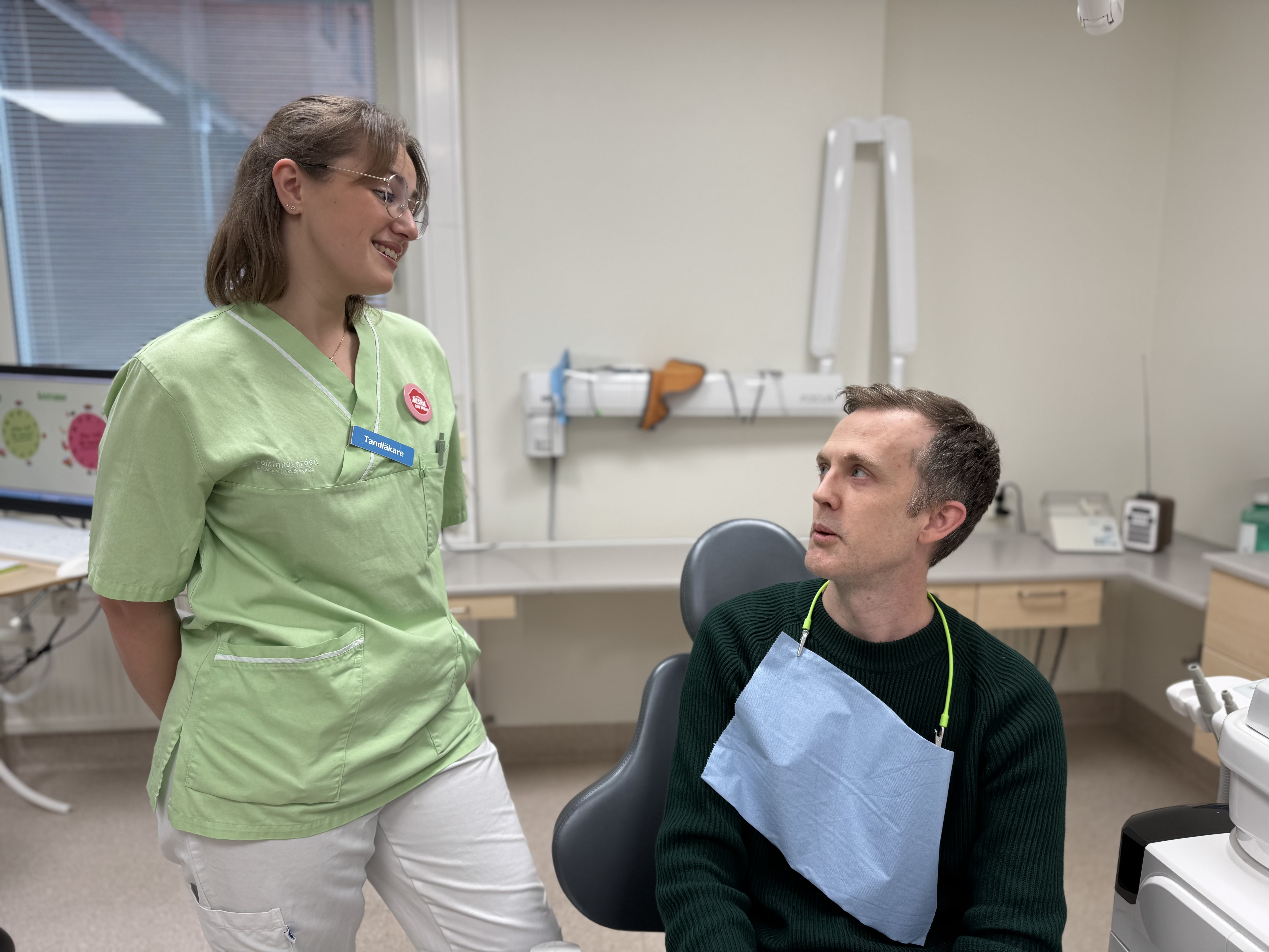 Tandhygienisten instruerar patienten hur han ska borsta sina tänder. 