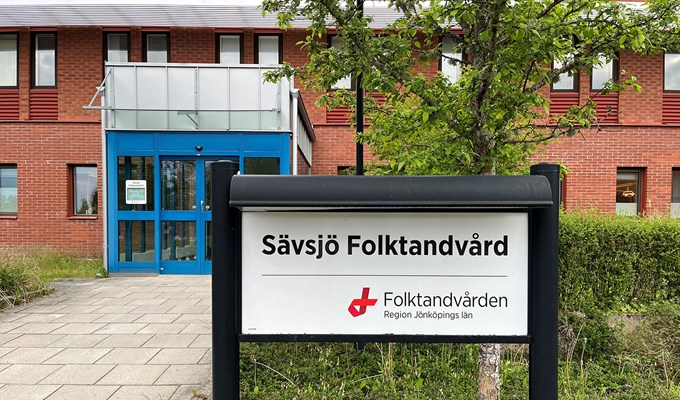 Sävsjö Folktandvård entré. Röd tegelbyggnad med en blå dörr.