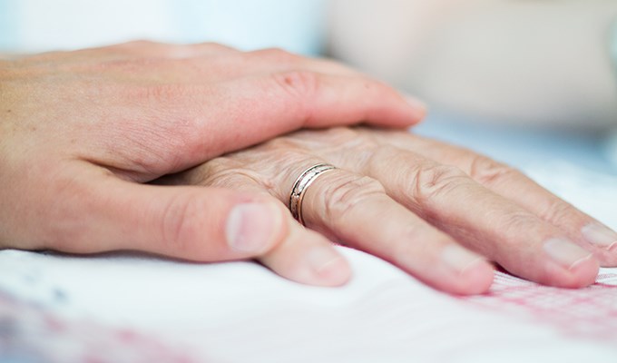 En hand som håller en äldres hand