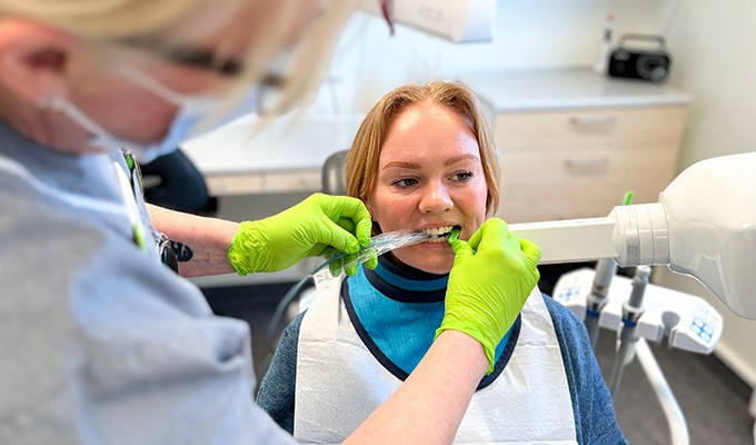 En tandhygienist förbereder en patient för röntgen.