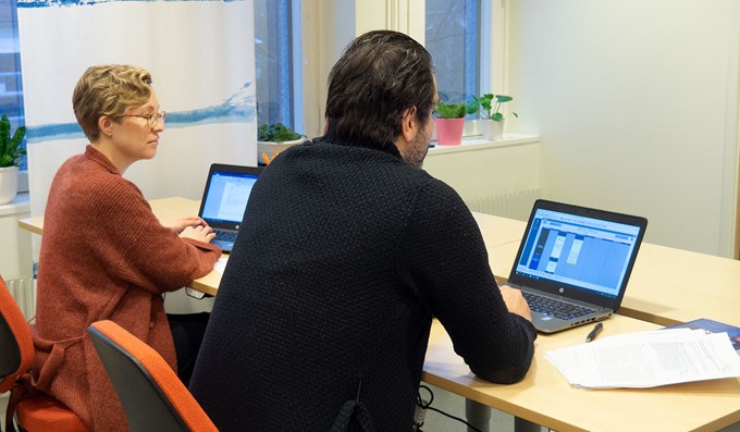 Två personer på kurs framför varsin dator.