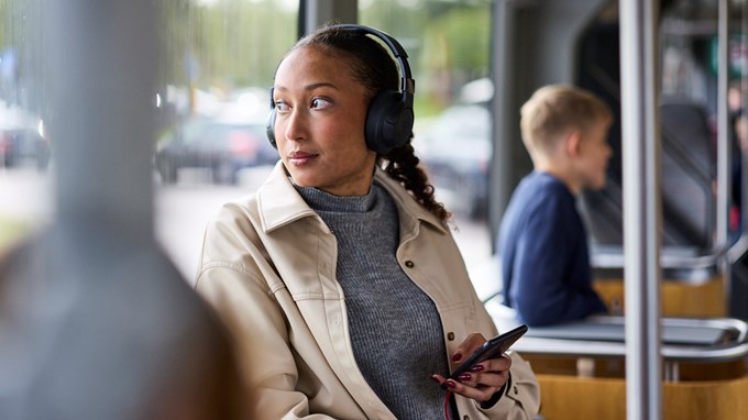 En ung vuxen som tittar ut genom fönstret på en buss.