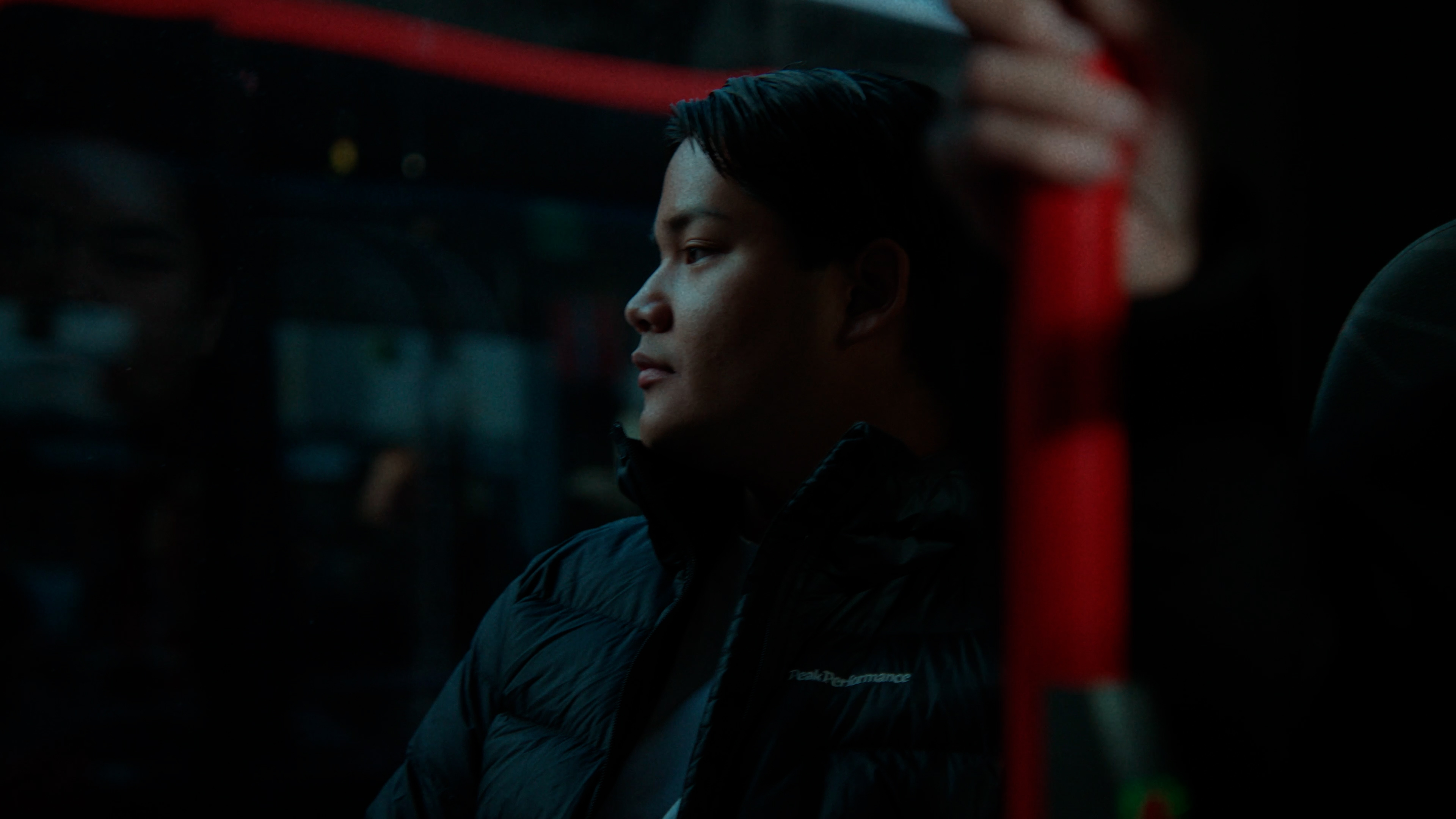 En person sitter på en buss och tittar ut genom fönstret.