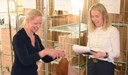 Två glada tjejer framför vagnar med varuprover.