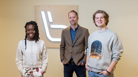 Tre medarbetare från Länstrafiken står bredvid varandra och ler mot kameran.