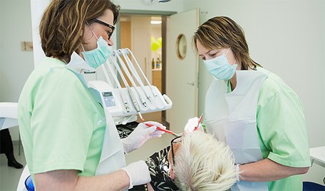 Två tandläkare framför en patient