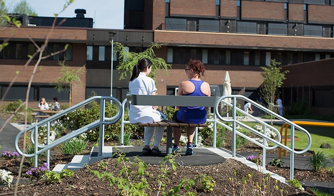 Kvinnlig sjukgymnast arbetar utomhus med en kvinnlig patient. 