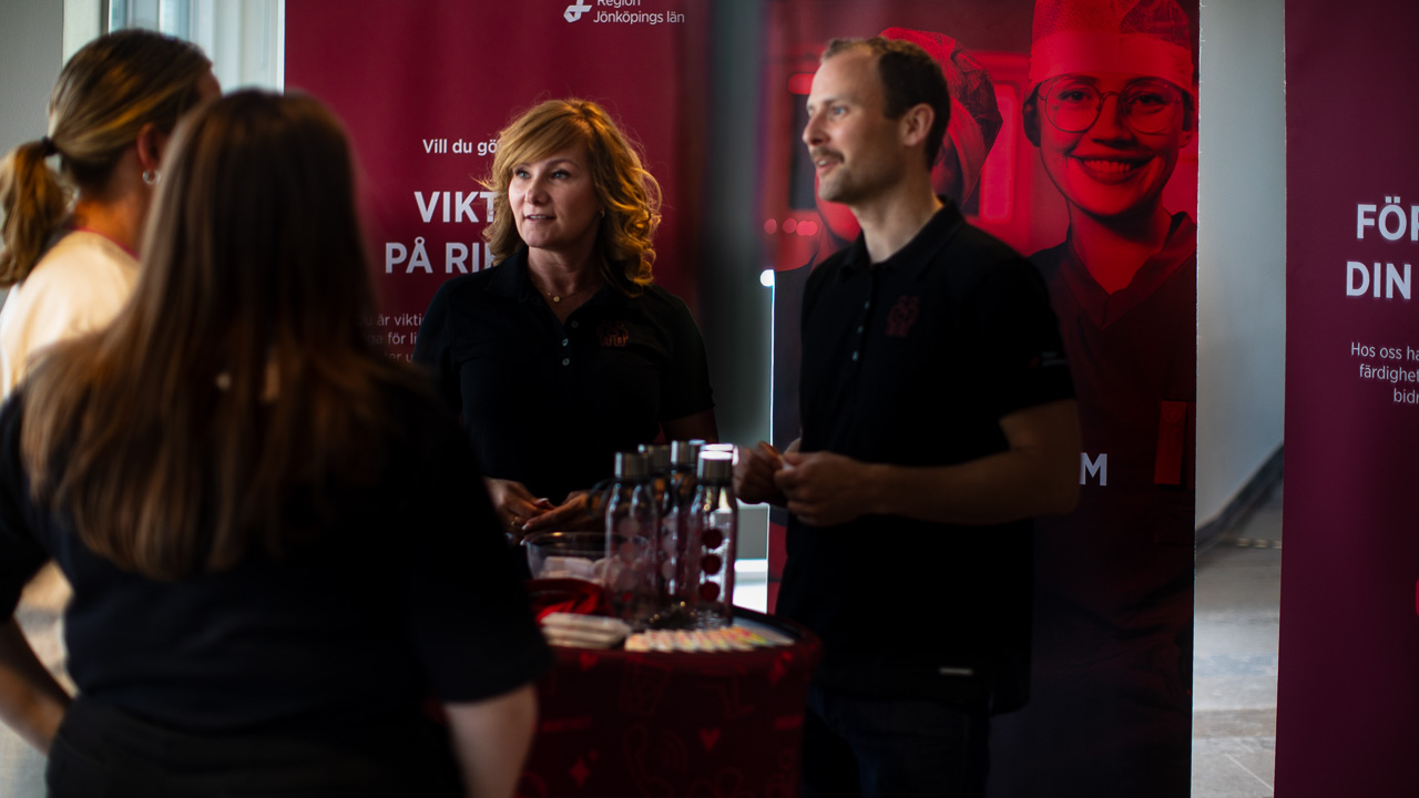 Tre personer står och samtalar med varandra på en jobb-mässa