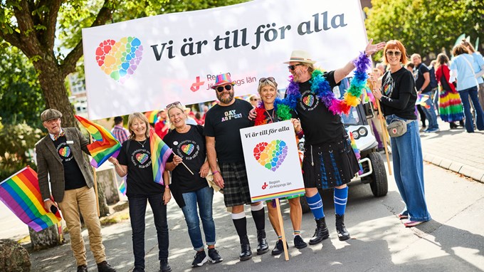 Flera personer är samlade under banderollen Vi är till för alla Region Jönköpings län under pride i Jönköping 2025. 