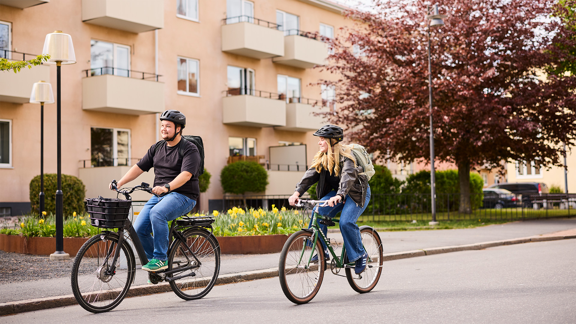 Personer cyklar genom ett blomstrande Jönköping. 