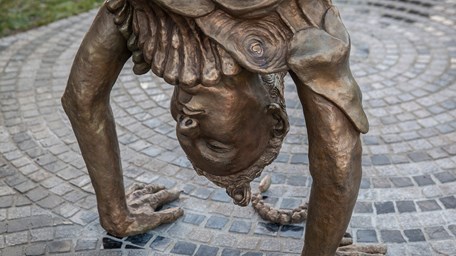 En kvinna dansar bland tyger i olika färger.