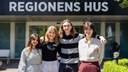 Fyra unga personer framför Regionens Hus. 