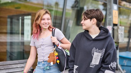 Två ungdomar ler mot varandra.