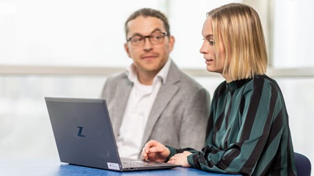 En man och en kvinna arbetar tillsammans vid en dator.