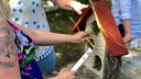 Deltagare samlade runt ett bord där de bygger insektshotell i trä.