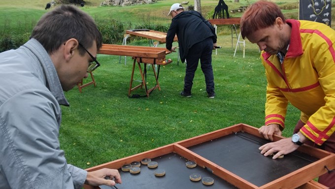 Tre personer spelar spel utomhus i naturen