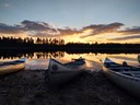 Kanoter ligger vid en sjö i solnedgång