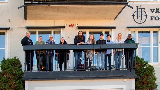 En grupp människor står på en balkong tillhörande Värnamo Folkhögskola
