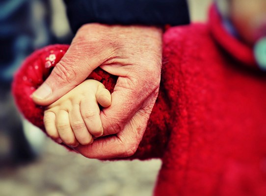 äldre hand håller i en barnhand