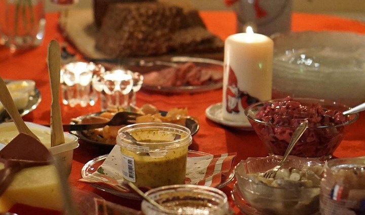 Del av ett dukat julbord och levande ljus