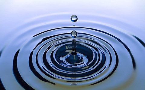 droppe skapar ringar på vattenytan